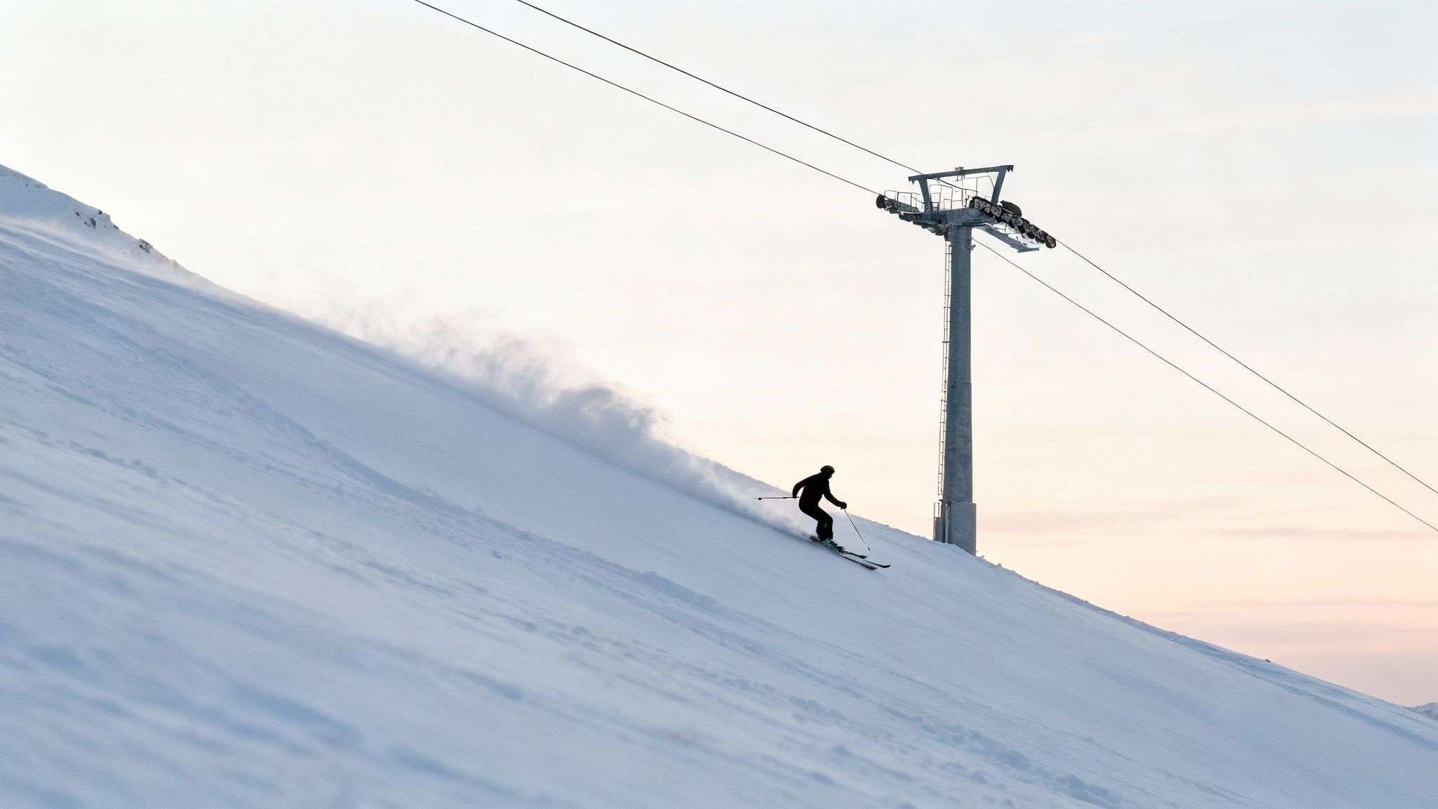 A skier carves a turn in fresh powder at Alta Ski Area, with a mountain lift and snowy peaks in the background.