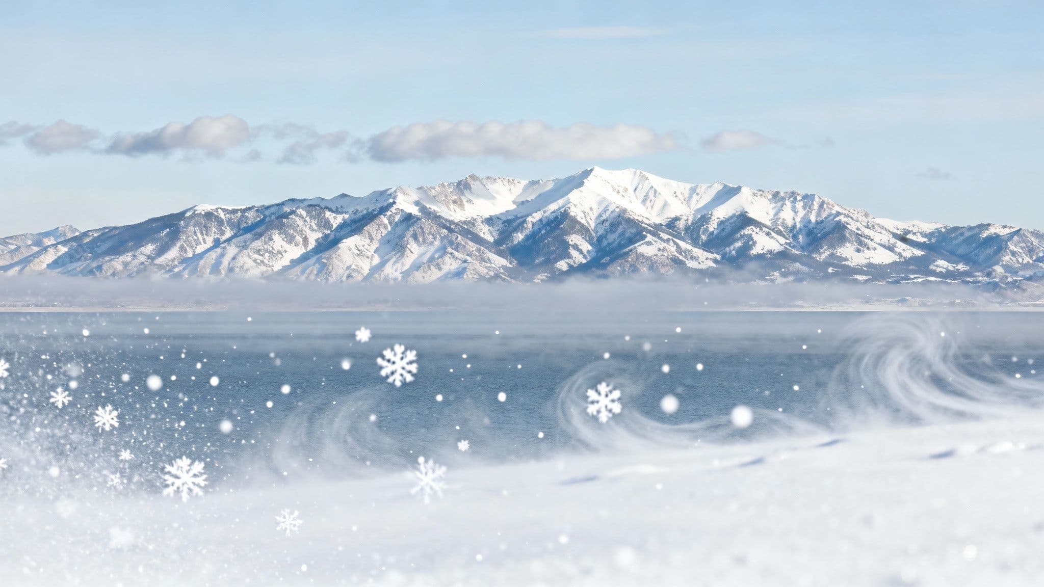 A skier makes fresh tracks in deep powder with snow-covered mountains in the background at Snowbird.