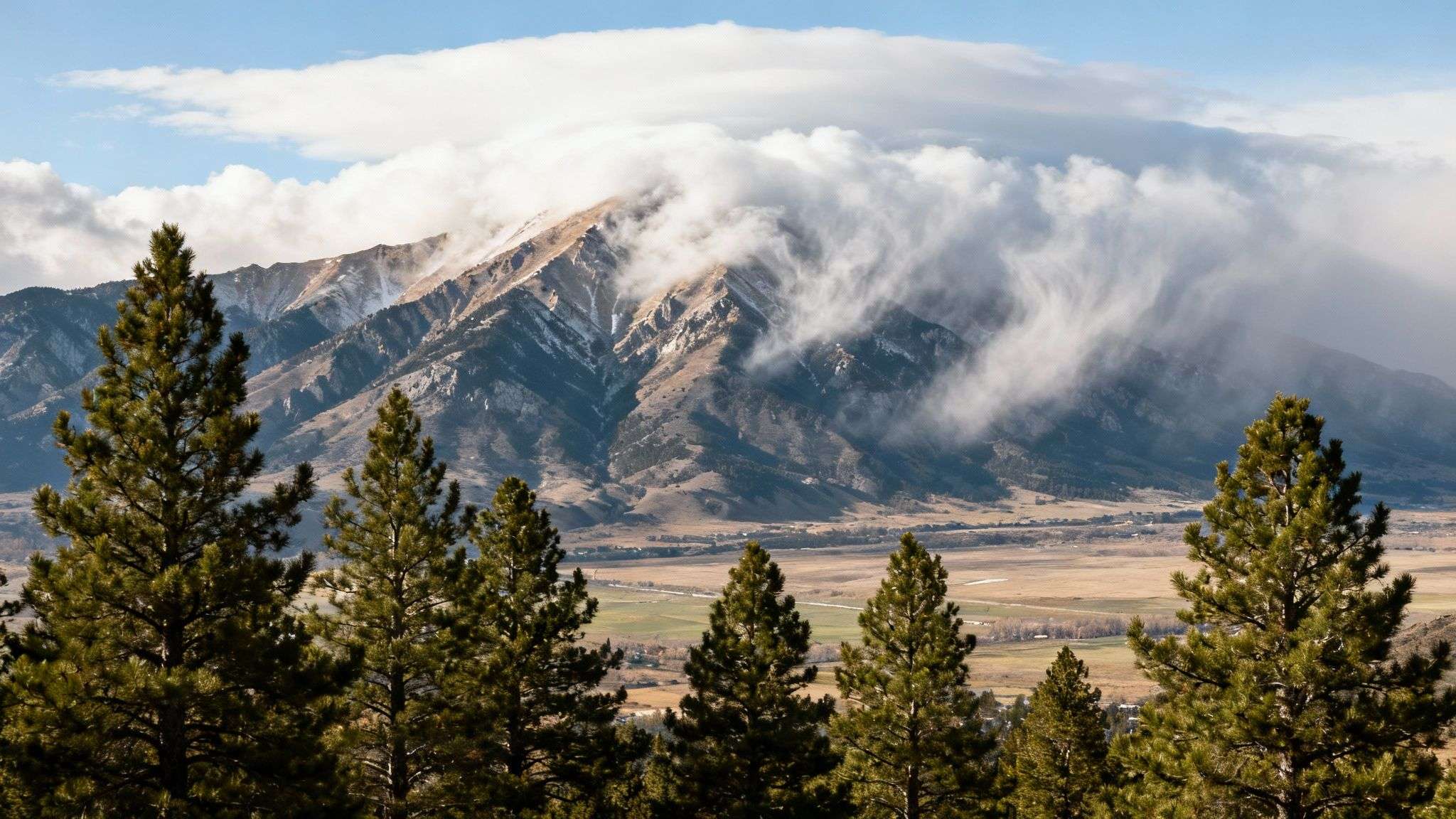 Storm clouds gathering over the mountains in Parleys Canyon, with sunlight breaking through to highlight the dramatic landscape.